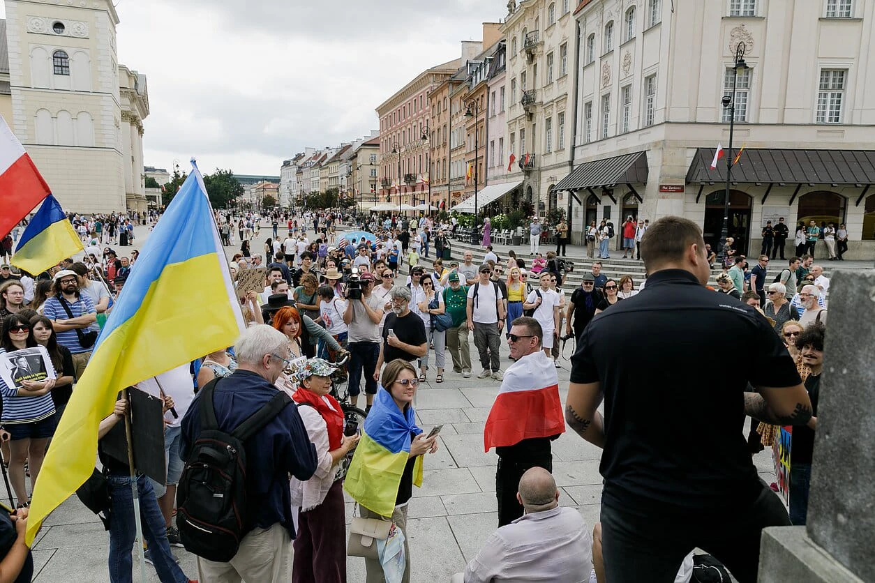 Учасники "Пікету добросусідства" на Замковій площі у Варшаві біля Колони Сигізмунда з прапорами Польщі, України та вільної